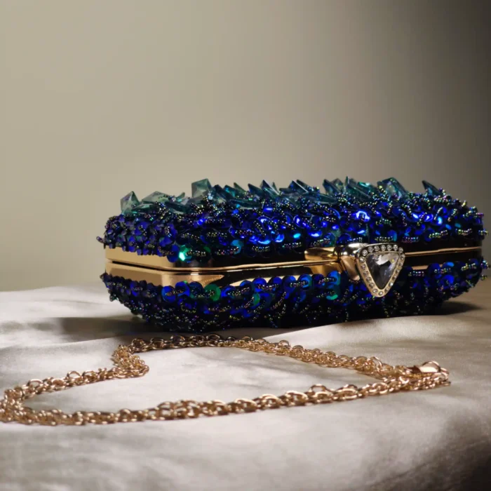 Blue crystal embellished evening clutch bag with gold frame and detachable chain strap