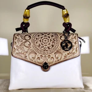 Ivory embossed top handle satchel bag with handle, a floral flap design, and detachable printed shoulder strap.