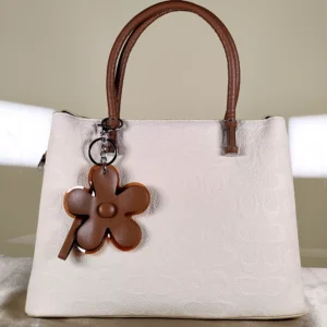 Ivory textured top handle satchel handbag with tan handles, detachable shoulder strap, and floral charm for women