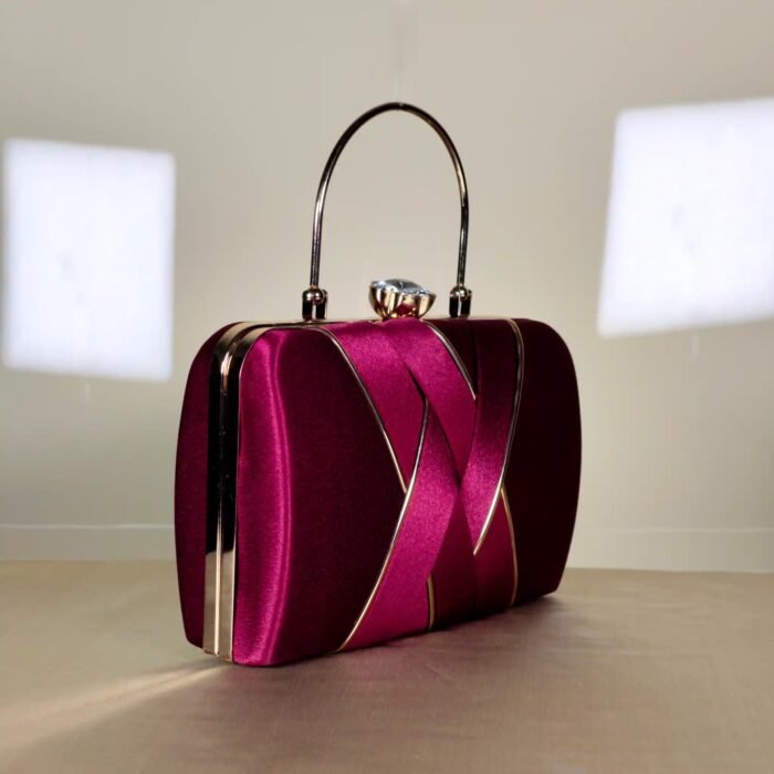 Compact structured clutch bag with decorative overlapping front detailing and a sleek top handle