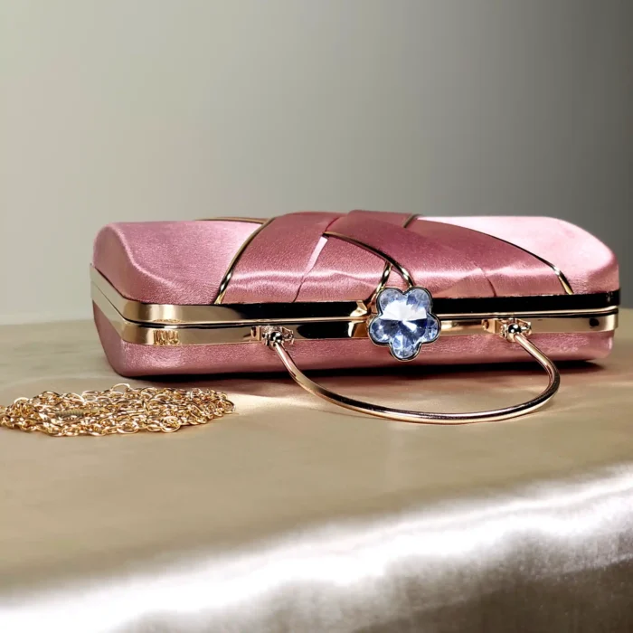 A sophisticated structured clutch bag featuring an elegant rectangular silhouette, decorative overlapping front detailing, and a sleek top handle. Perfect for adding a refined touch to evening and special-occasion outfits.