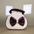 Ivory shoulder bag with burgundy bow detail and ruched handle