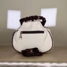 Ivory shoulder bag with burgundy bow detail and ruched handle